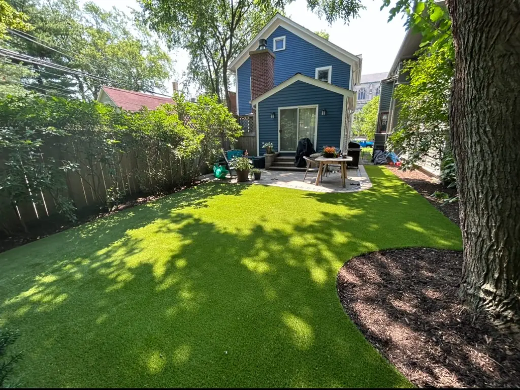 Green lawn and planting beds behind a blue house