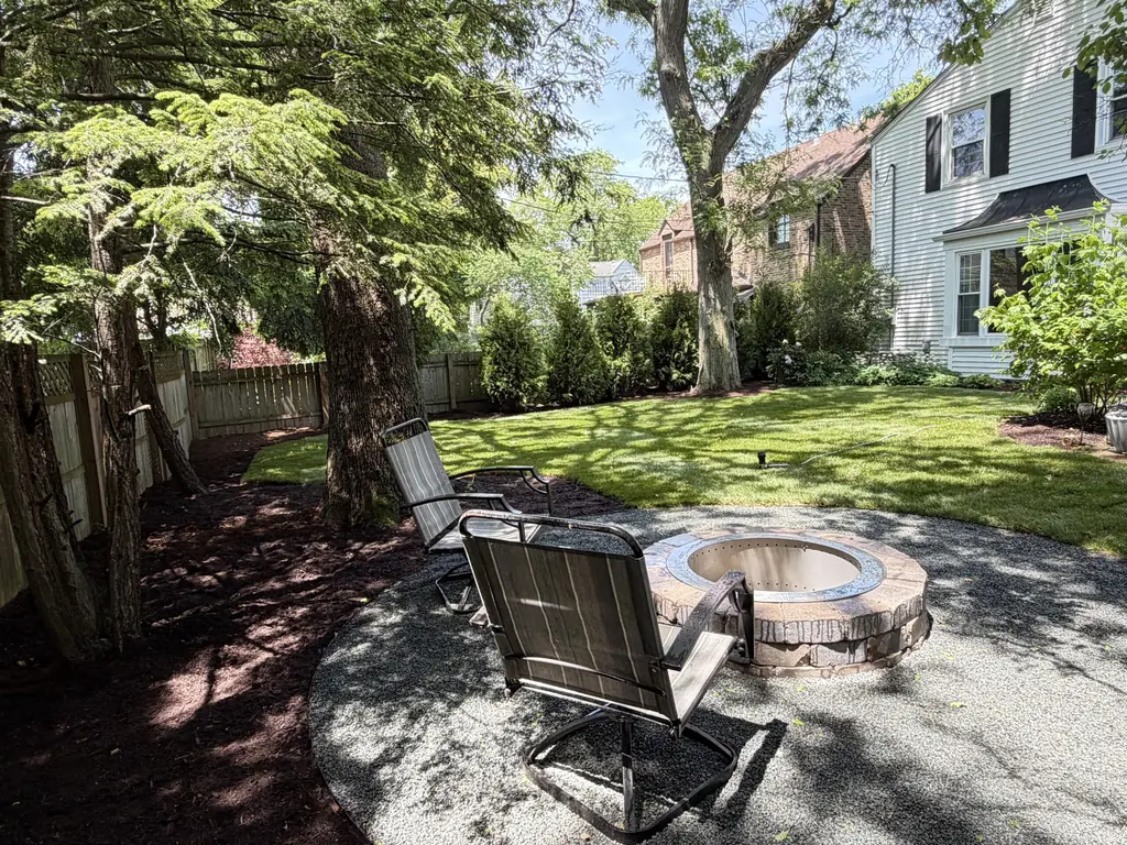Backyard fire pit with seating surrounded by trees